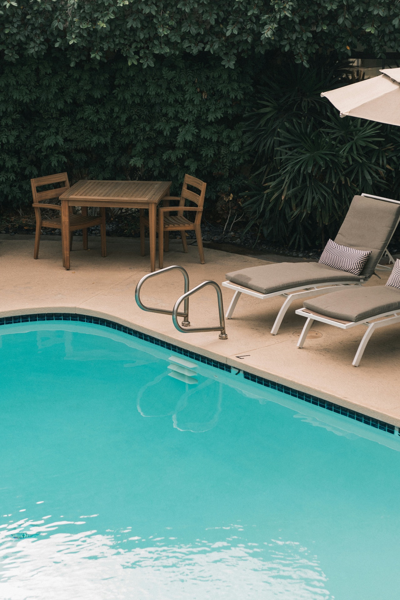 Inviting private pool with lounge chairs and lush greenery.