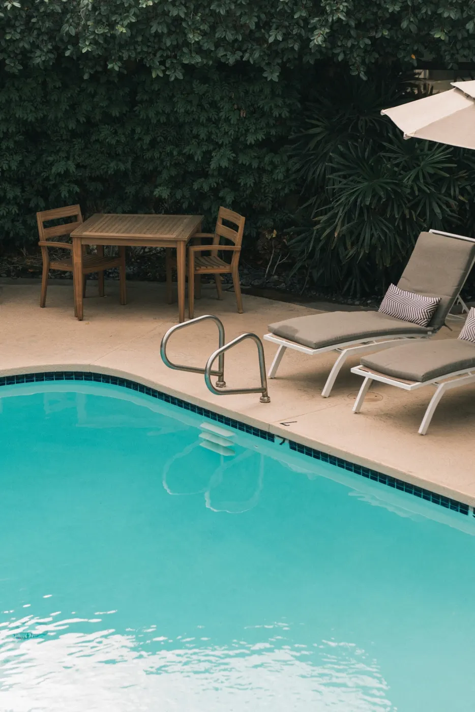 Inviting private pool with lounge chairs and lush greenery.